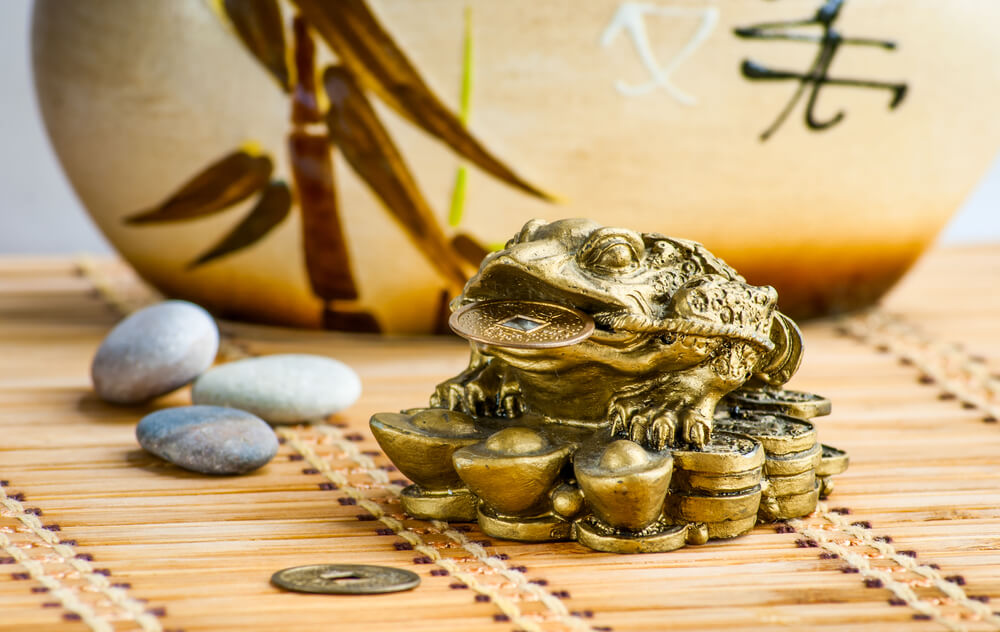 gold frog and coins in a bamboo mat