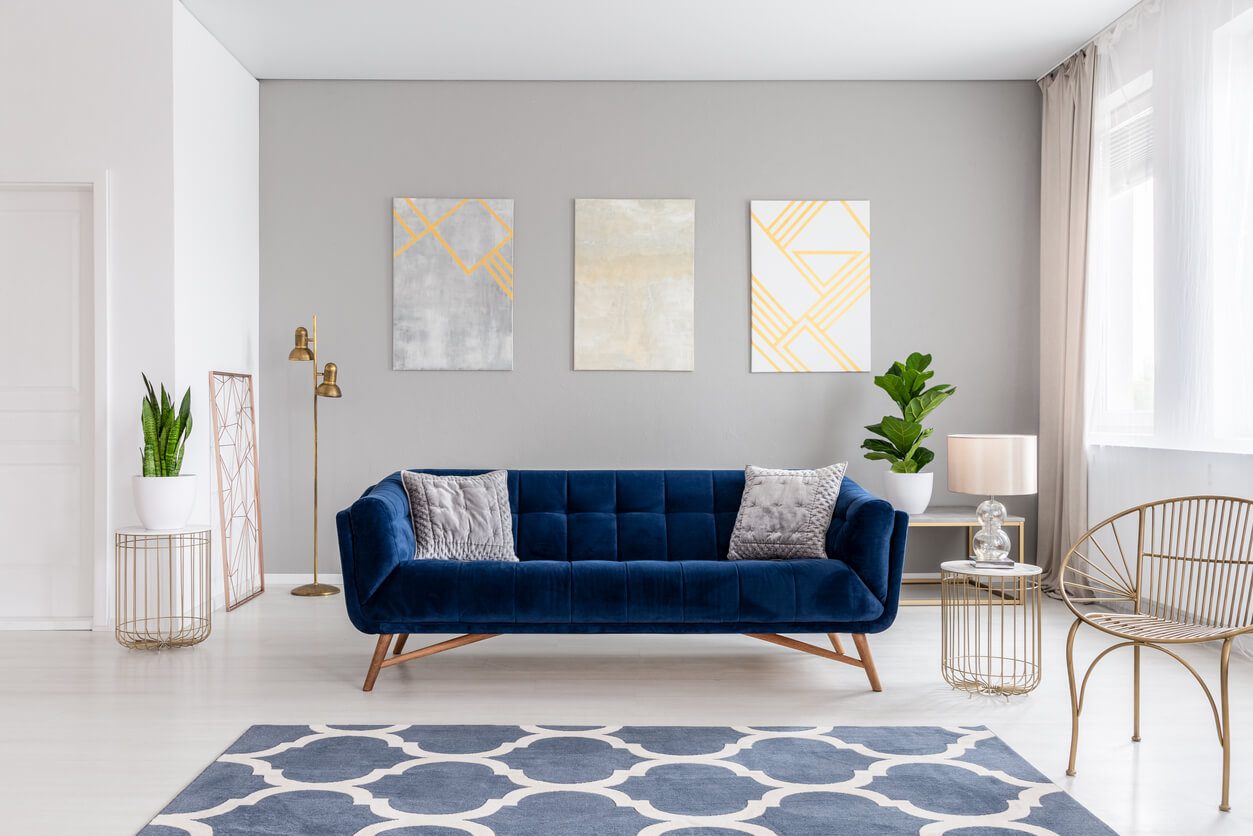 dark blue couch against a grey wall