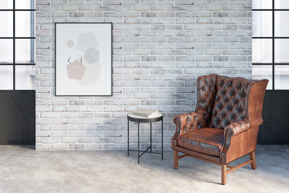leather chair against white brick