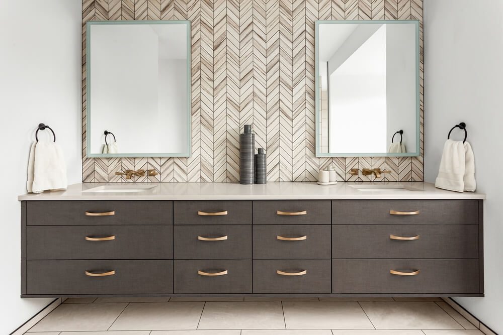 herringbone tile backsplash with floating cabinets on contemporary bathroom