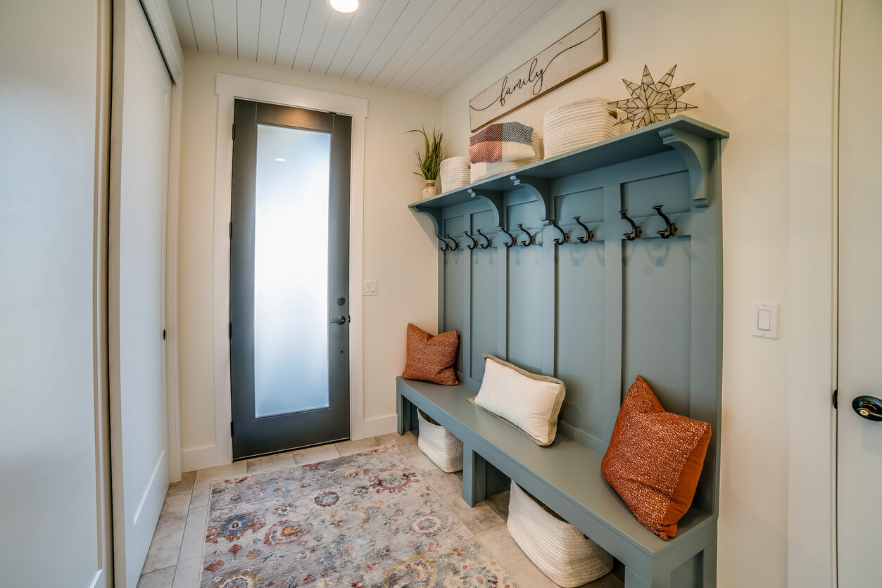 simple and elegant mudroom with rust throwpillows